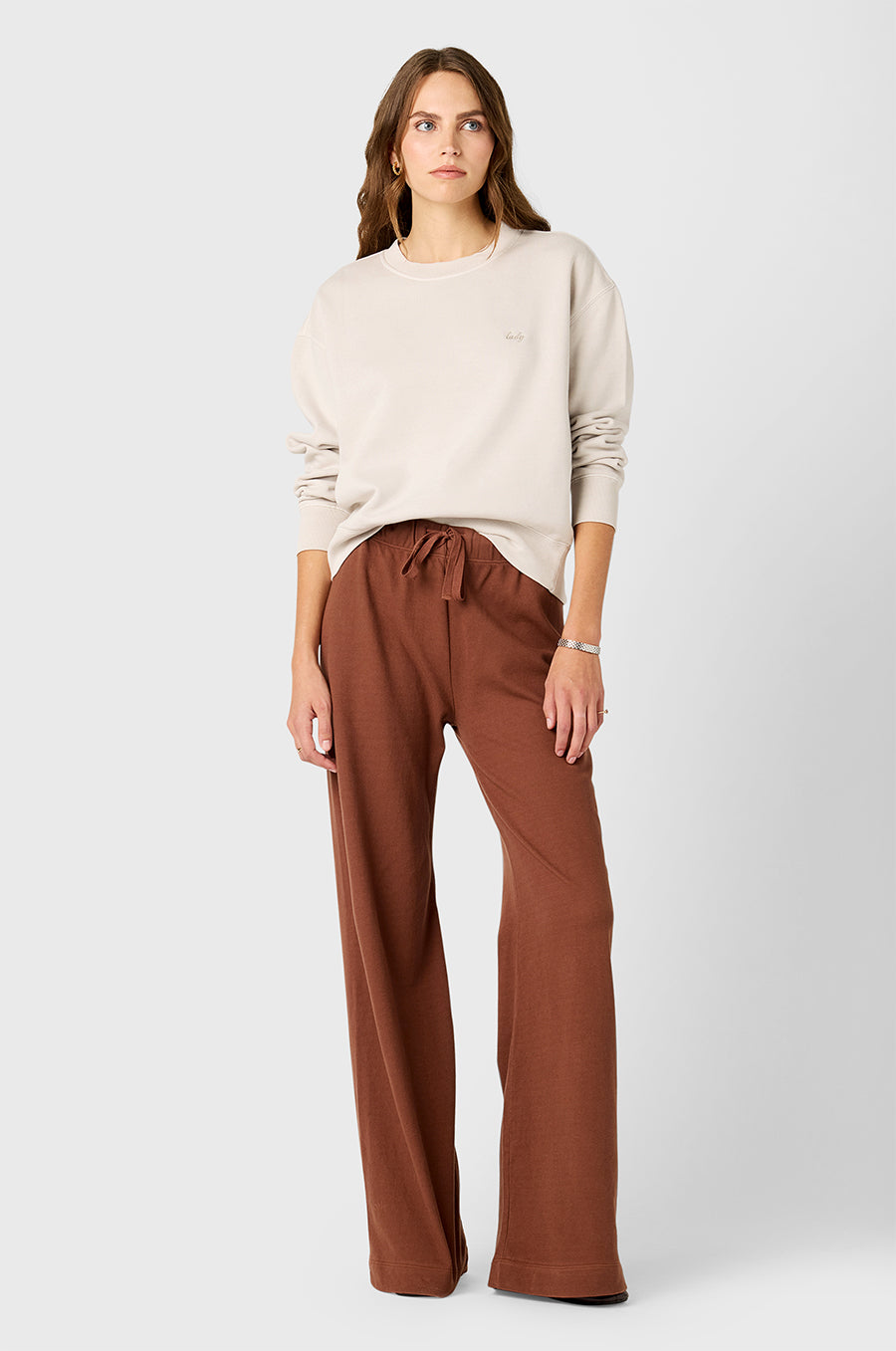 Model wearing The Lady & The Sailor's Tomboy Sweatshirt in Washed Ecru with Lady Embroidery and Wide Leg Pant in Chestnut Cotton Twill.